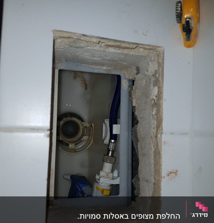 צינור מים כחול וחלקי אינסטלציה בתוך קיר